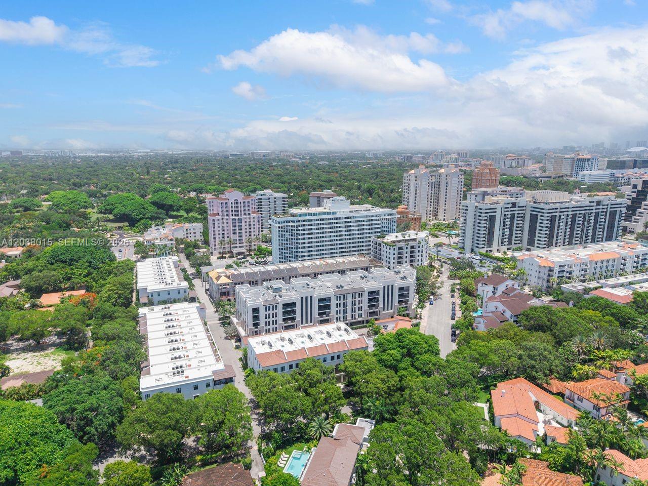 An aerial view shows a dense residential complex surrounded by lush green trees and buildings — 718 Valencia Ave # 403, Coral Gables FL 33134, CORAL GABLES, FL