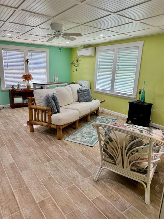 A living room features a bamboo sofa, a patterned armchair, and light-colored tile flooring — 3022 56TH STREET S, GULFPORT, FL