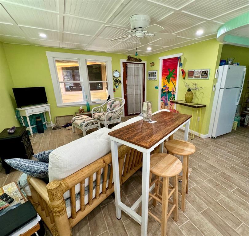 A living room features lime green walls, a bamboo sofa, and a high-top wooden table — 3022 56TH STREET S, GULFPORT, FL