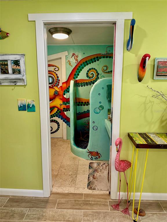 A doorway leads to a bathroom featuring a colorful octopus mural and a custom shower — 3022 56TH STREET S, GULFPORT, FL