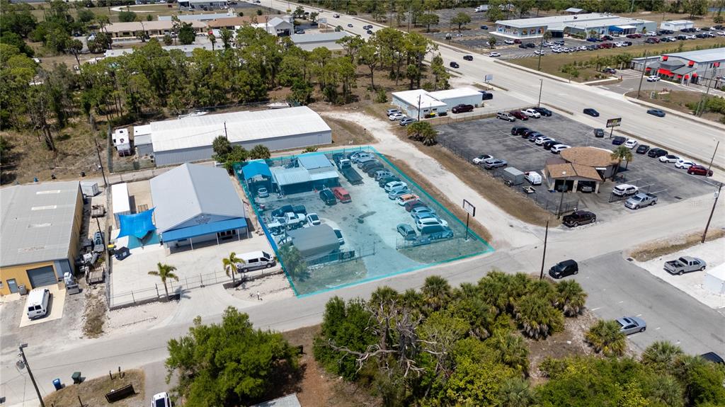 An aerial view shows a commercial property with a fenced lot and several buildings — 54 HARVARD STREET, ENGLEWOOD, FL