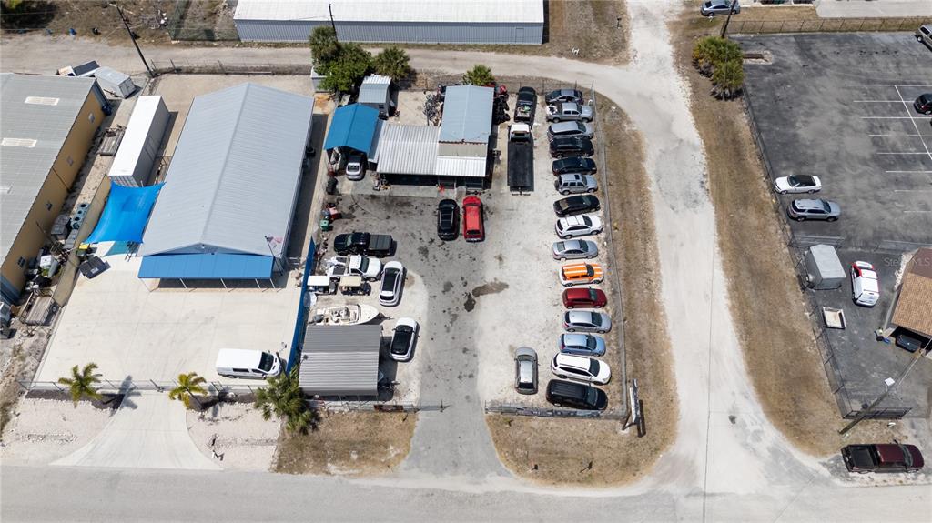 An aerial view shows a commercial property with two metal buildings and a parking lot — 54 HARVARD STREET, ENGLEWOOD, FL