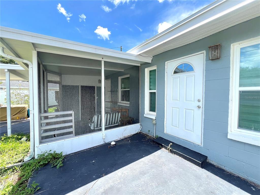 A screened-in porch sits beside a white door on the side of a house — 3806 6TH AVENUE N UNIT 1/2, ST PETERSBURG, FL
