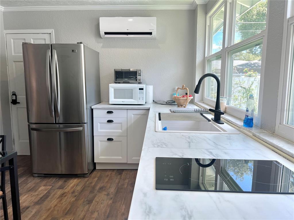 A kitchen features stainless steel appliances, white cabinets, marble-look countertops, and a black faucet — 3806 6TH AVENUE N UNIT 1/2, ST PETERSBURG, FL
