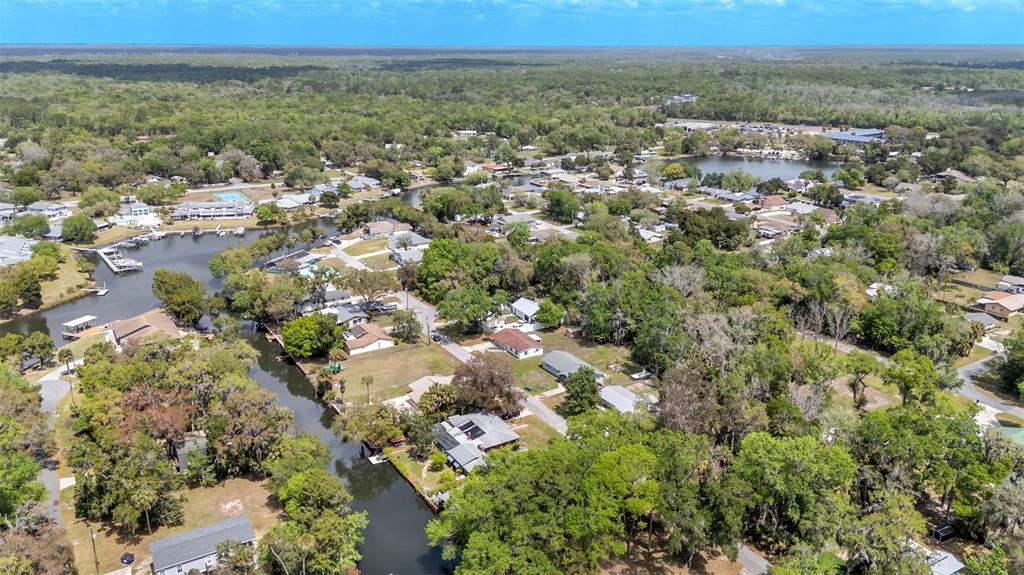 An aerial view shows a residential neighborhood with houses situated along a winding canal — 3781 N HIAWATHA TERRACE, CRYSTAL RIVER, FL