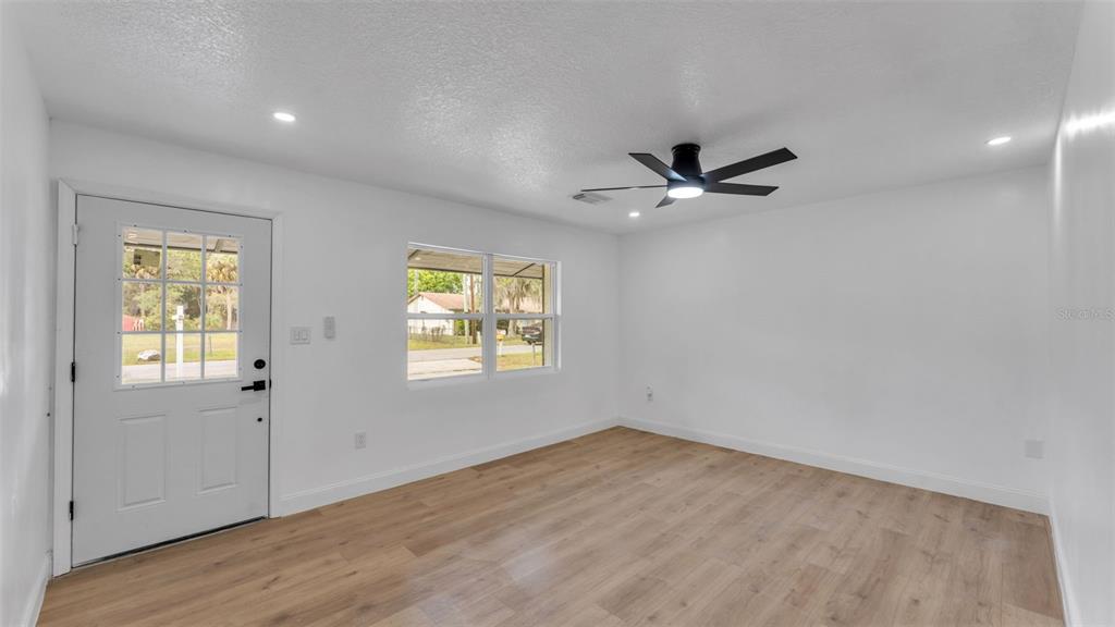 A bright room with white walls, light wood-look flooring, a ceiling fan, and a door — 3781 N HIAWATHA TERRACE, CRYSTAL RIVER, FL