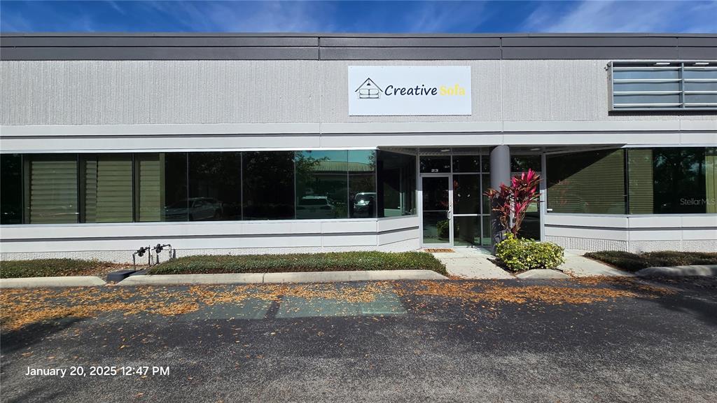 The exterior of a commercial building features a glass entrance and a Creative Sofa sign — 7901 KINGSPOINTE PARKWAY UNIT 23, ORLANDO, FL