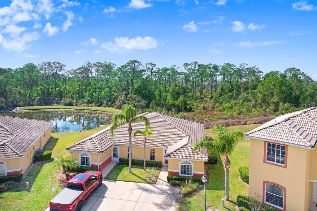 An aerial view shows a single-story house with a red truck parked in the driveway — 116 OCEAN BLUFF DRIVE, KISSIMMEE, FL