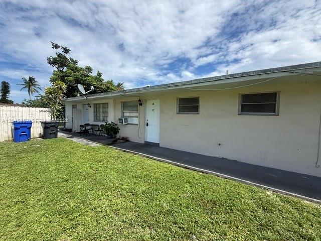 A single-story building with a white exterior, a concrete walkway, and a grassy yard — 5946 Mckinley St # B, Hollywood FL 33021, HOLLYWOOD, FL