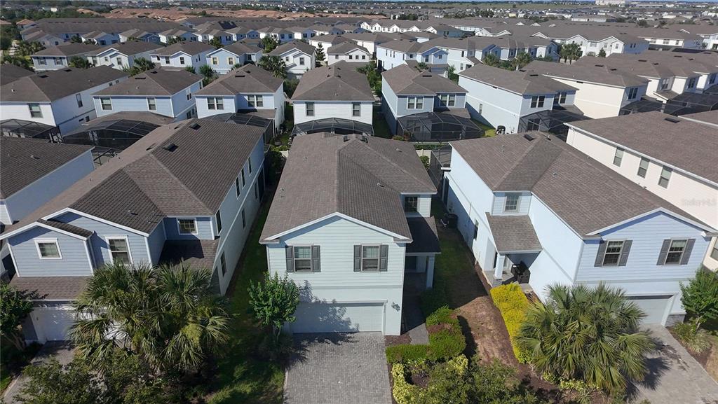An aerial view shows a two-story suburban house with a gray roof and light-colored siding — 8926 ZURICH LANE, KISSIMMEE, FL