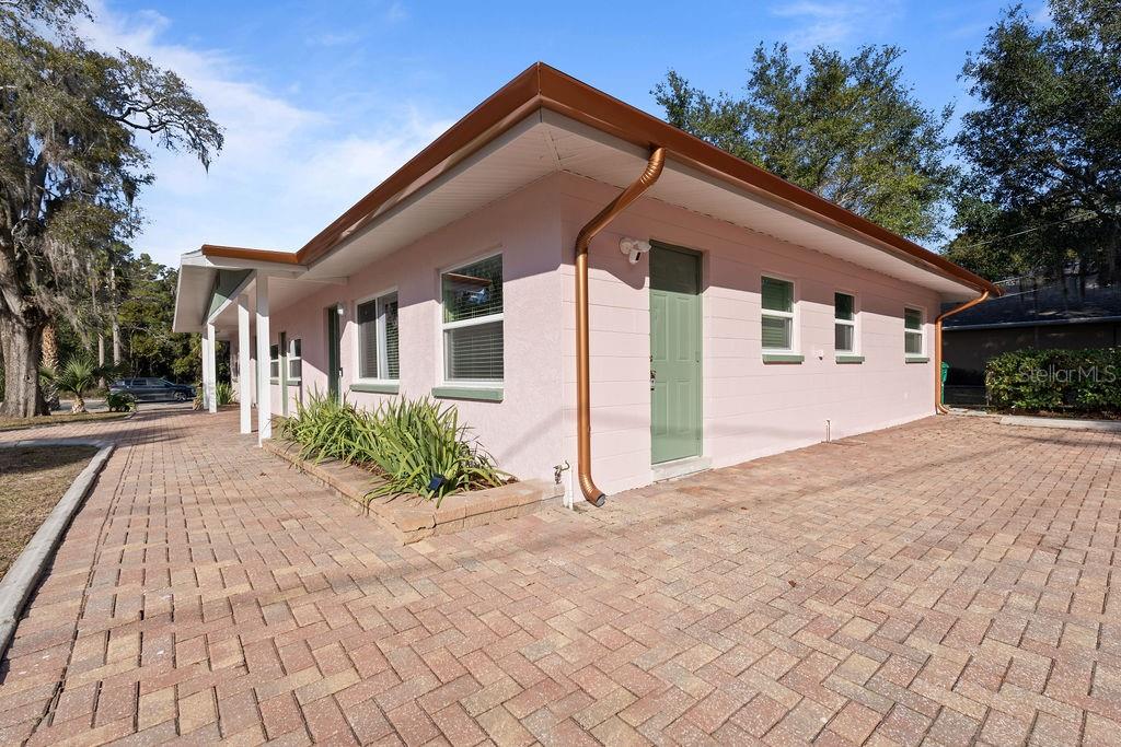 A pink, single-story building with a green door and a brick-paved driveway — 11987 MAPLE STREET UNIT 2, DUNNELLON, FL