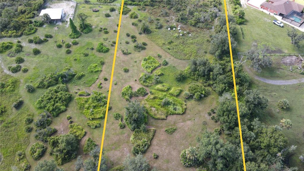 An aerial view of a large, grassy, partially wooded plot of land with yellow boundary lines — 15650 WATER OAK COURT, PUNTA GORDA, FL