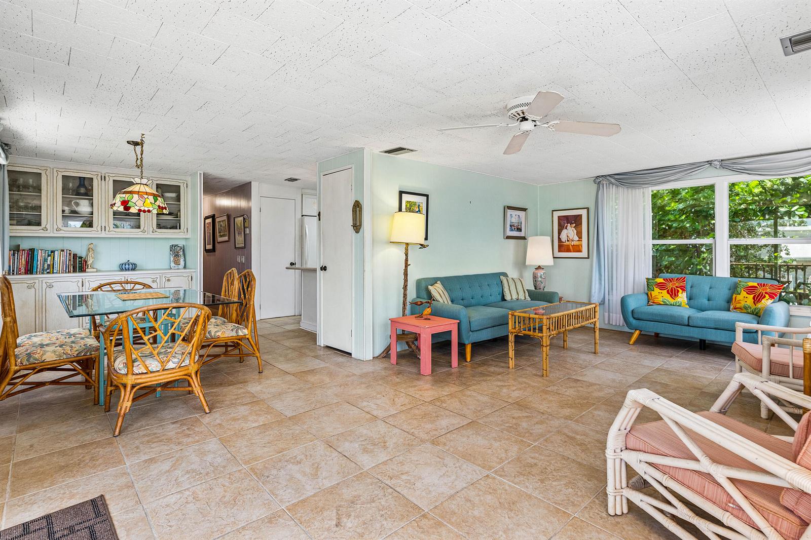 A living and dining area features tile floors, light blue walls, and rattan furniture — 205 S Ibis Drive # R, Briny Breezes FL 33435, BRINY BREEZES, FL
