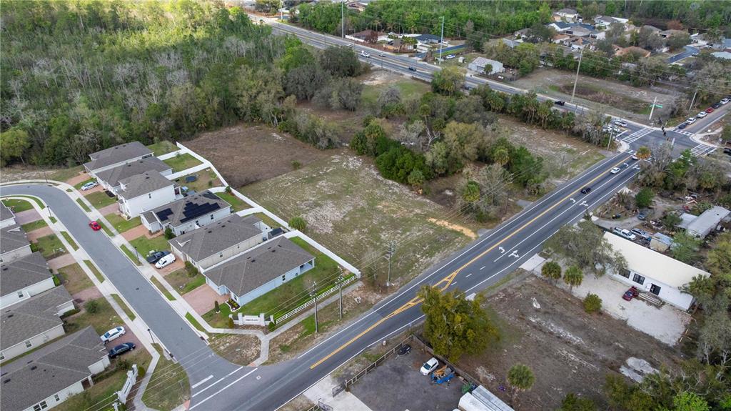 An aerial view shows a vacant lot situated between a residential neighborhood and a road — 6211 COUNTY ROAD 547 N, DAVENPORT, FL