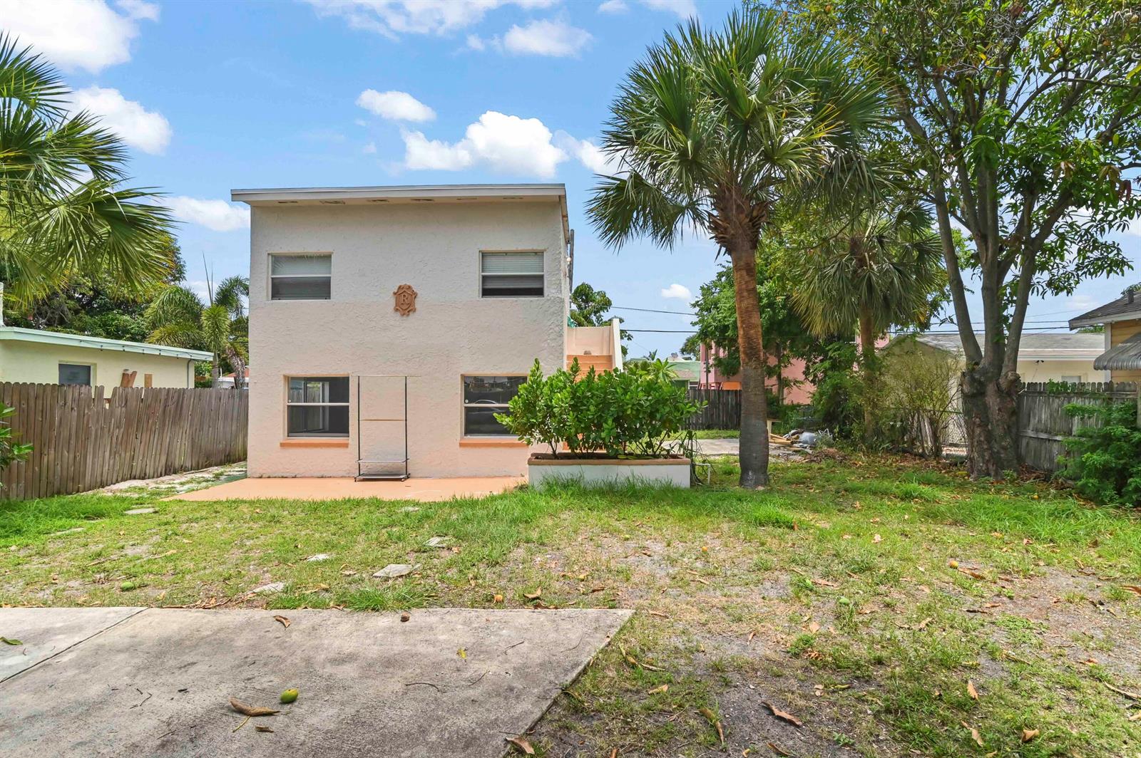 The exterior of a two-story stucco building features a backyard with a palm tree — 515 Putnam Road, West Palm Beach FL 33405, WEST PALM BEACH, FL