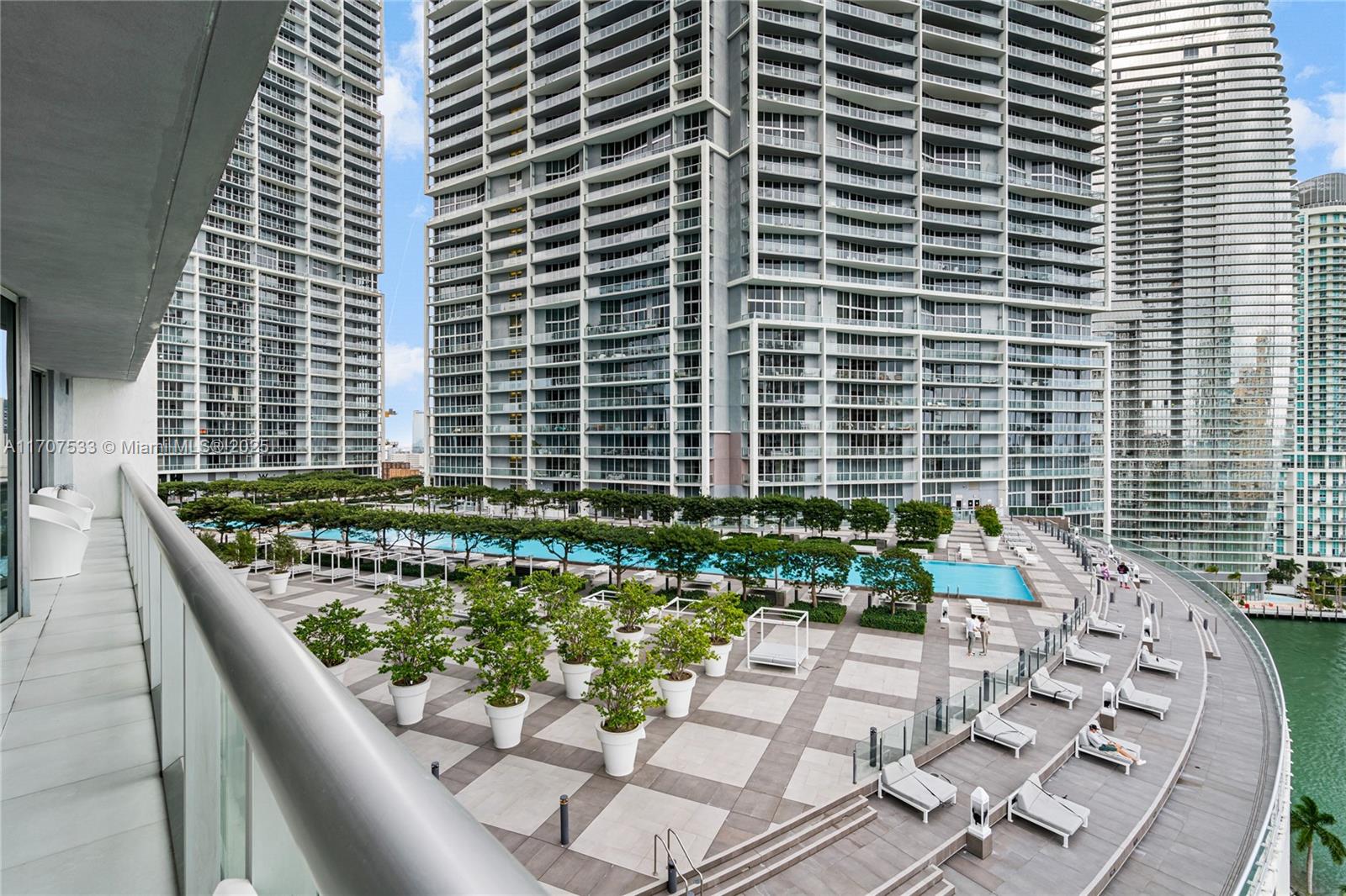 A high-angle view shows a large outdoor terrace with a swimming pool and lounge chairs — 495 Brickell Ave # 1702, Miami FL 33131, MIAMI, FL