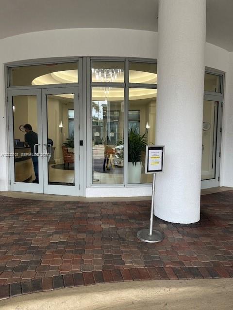 The exterior entrance features glass double doors, a large white column, and brick pavers — HOLLYWOOD, FL