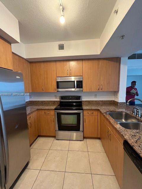 A kitchen features light wood cabinets, stainless steel appliances, and a granite countertop — HOLLYWOOD, FL