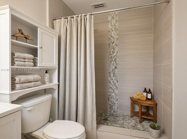 A bathroom features a toilet, storage shelving, a shower with a curtain, and tile finishes — 1500 NE 137th St, North Miami FL 33161, NORTH MIAMI, FL