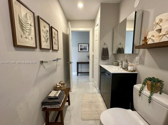 A modern bathroom features a dark vanity, a wooden bench, and framed botanical wall art — 1500 NE 137th St, North Miami FL 33161, NORTH MIAMI, FL