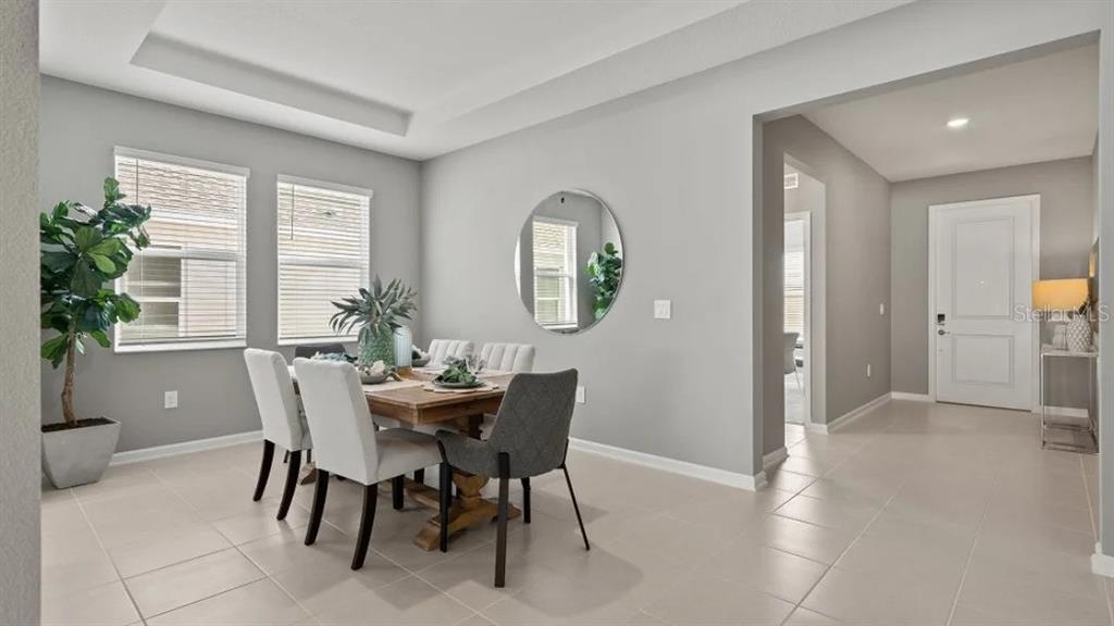 A dining room with light gray walls, tile flooring, a wooden table, and four chairs — 1801 RIDER RAIN LANE, APOPKA, FL