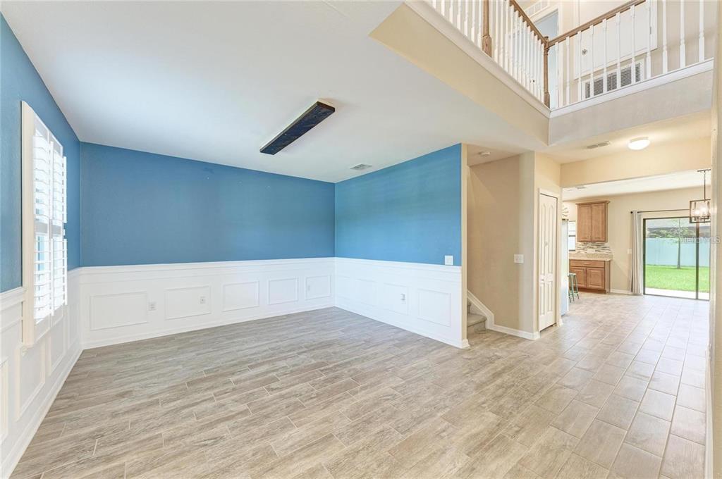 An empty room with blue walls, white wainscoting, and wood-look tile flooring — 2084 LA PALMA AVENUE, PORT CHARLOTTE, FL