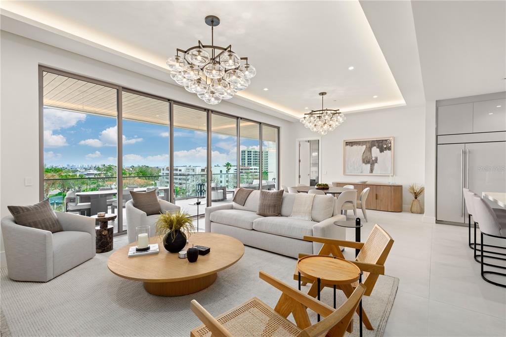 A modern, open-concept living and dining area features floor-to-ceiling windows, two bubble chandeliers, and neutral furniture — 1581 GULF OF MEXICO DRIVE UNIT 507, LONGBOAT KEY, FL