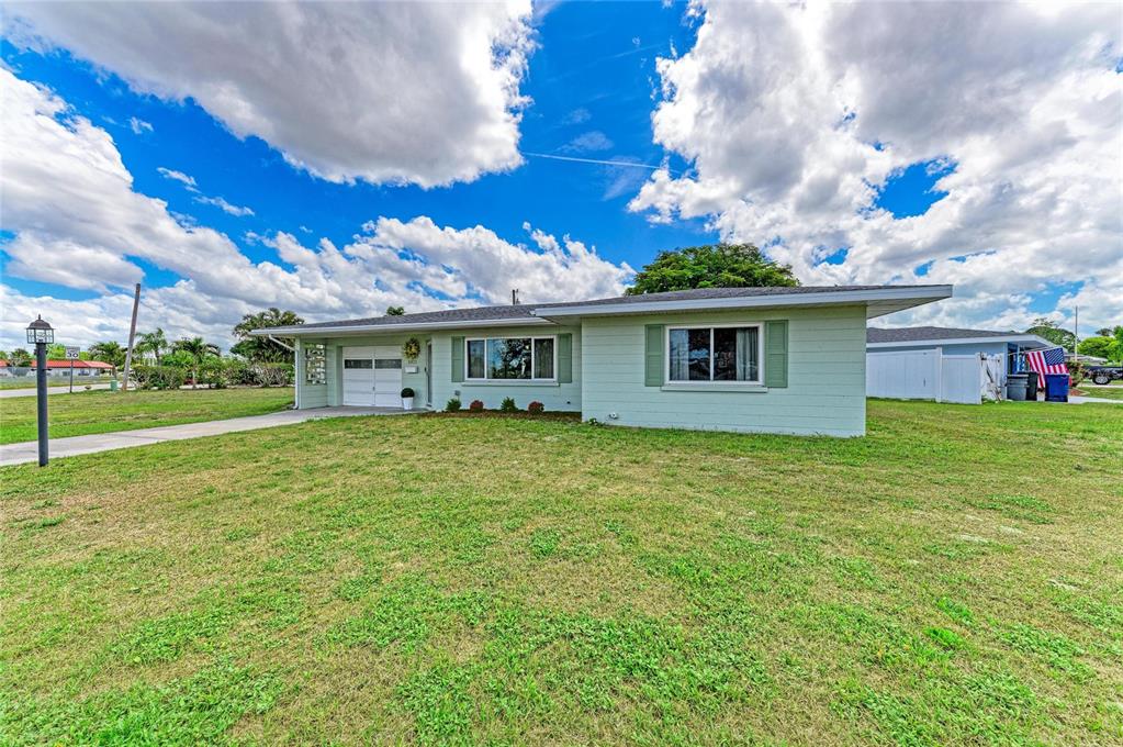 A light green single-story house with a white garage door and a large front lawn — 2811 33RD AVENUE W, BRADENTON, FL