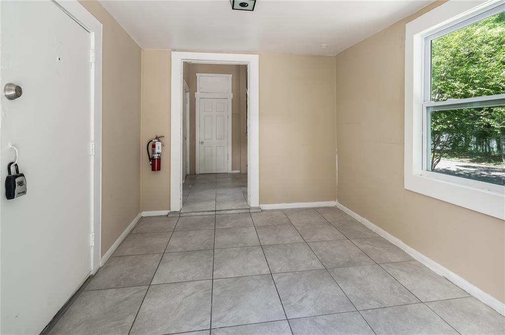 An entryway with light-colored tile flooring, beige walls, a white door, and a window — 418 E AMELIA AVENUE UNIT A, TAMPA, FL