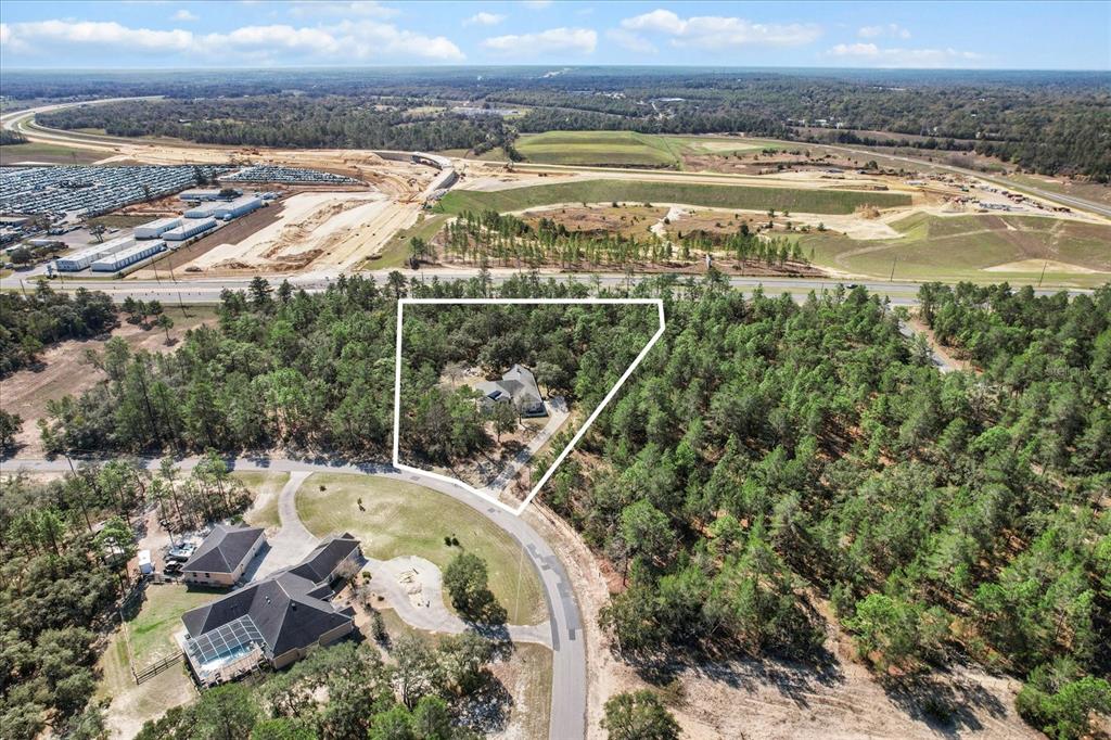 An aerial view shows a house situated on a wooded lot near a highway — 5194 W DEPUTY DRIVE, BEVERLY HILLS, FL
