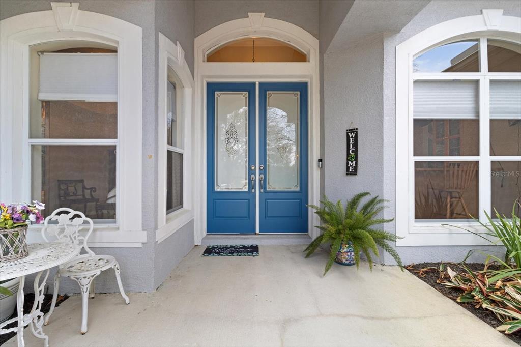 A front porch features a blue double door, a white bistro set, and a potted fern — 5194 W DEPUTY DRIVE, BEVERLY HILLS, FL