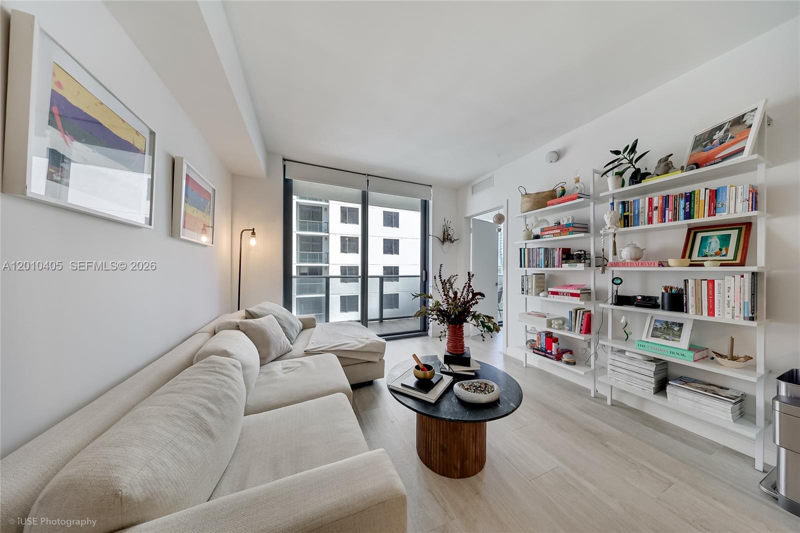 A living room features a beige sectional sofa, a round coffee table, and white shelving — 55 SW 9th St # 2109, Miami FL 33130, MIAMI, FL