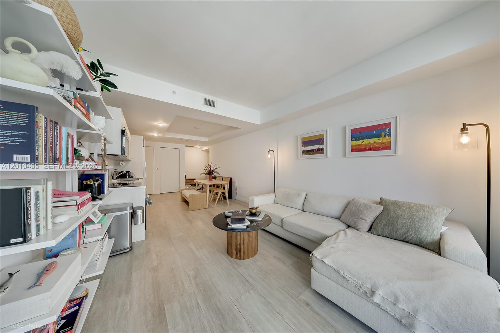 A bright living room features a white sectional sofa, a round coffee table, and open shelving — 55 SW 9th St # 2109, Miami FL 33130, MIAMI, FL