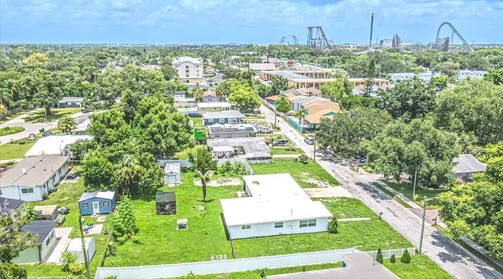 An aerial view shows a residential neighborhood with a white house and a large yard — 8706 RUTH PLACE, TAMPA, FL