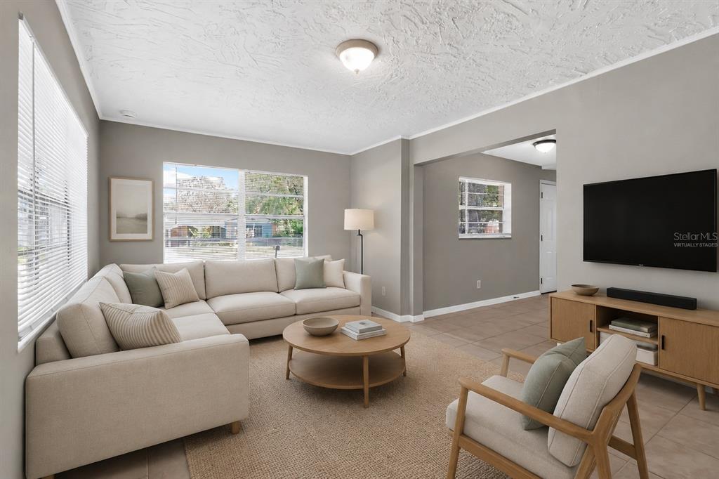 A living room with a sectional sofa, coffee table, armchair, and wall-mounted television — 2209 9TH COURT NE, WINTER HAVEN, FL
