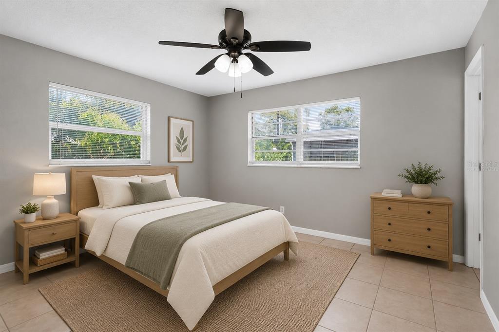 A bedroom with light gray walls, a wooden bed frame, and a matching dresser — 2209 9TH COURT NE, WINTER HAVEN, FL