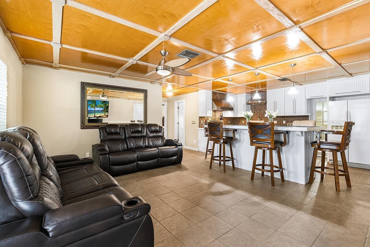 A living room and kitchen area featuring a coffered wood ceiling and tile flooring — 266 20th Avenue, Vero Beach FL 32962, VERO BEACH, FL