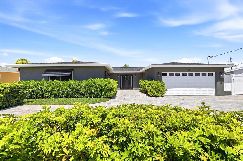 A single-story gray house with a white garage door and a paved front walkway — 121 79TH STREET S, ST PETERSBURG, FL