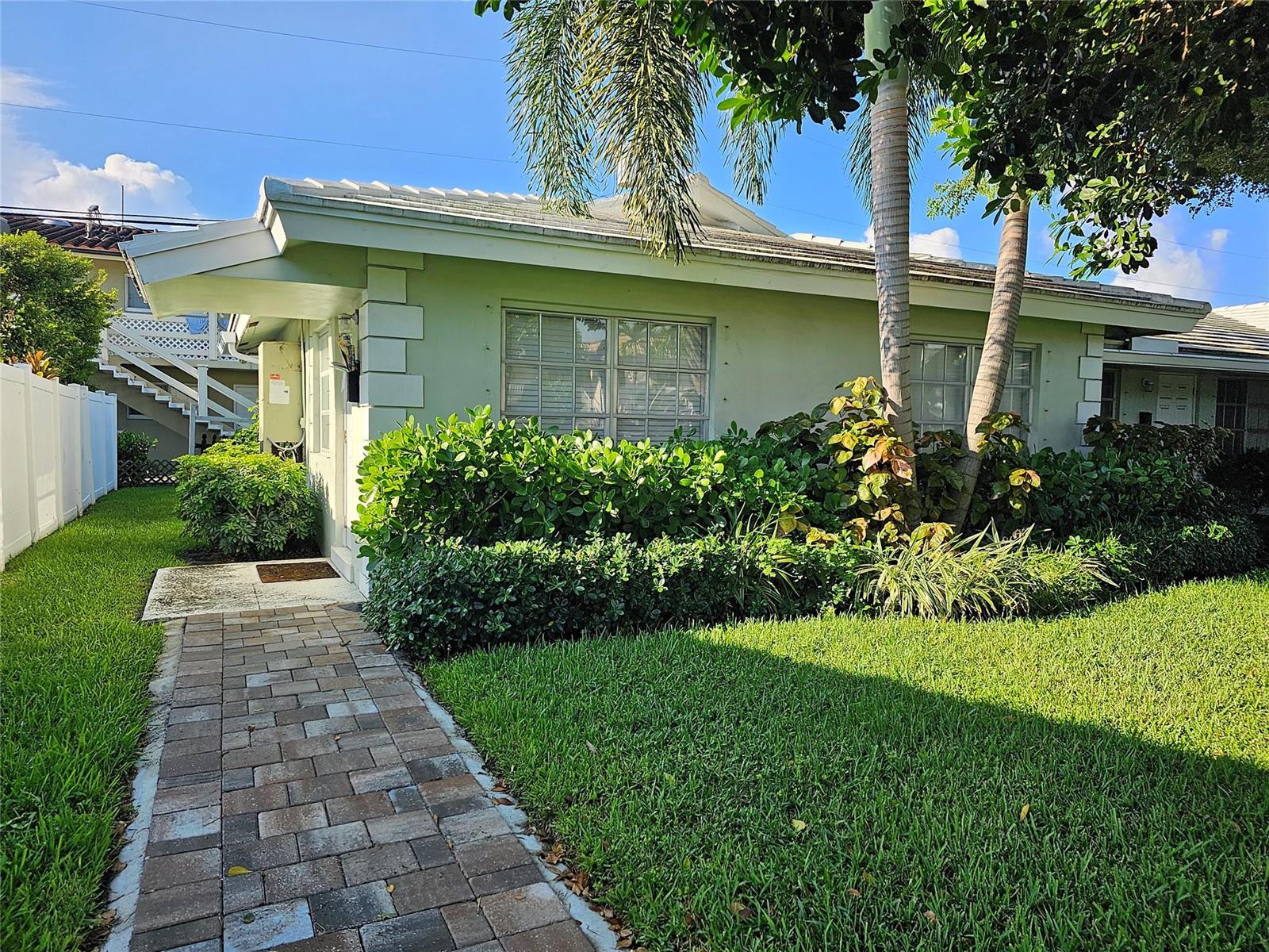 A light green house with a brick walkway and palm trees in the front yard — 2120 NE 41st Street # D, Lighthouse Point FL 33064, LIGHTHOUSE POINT, FL