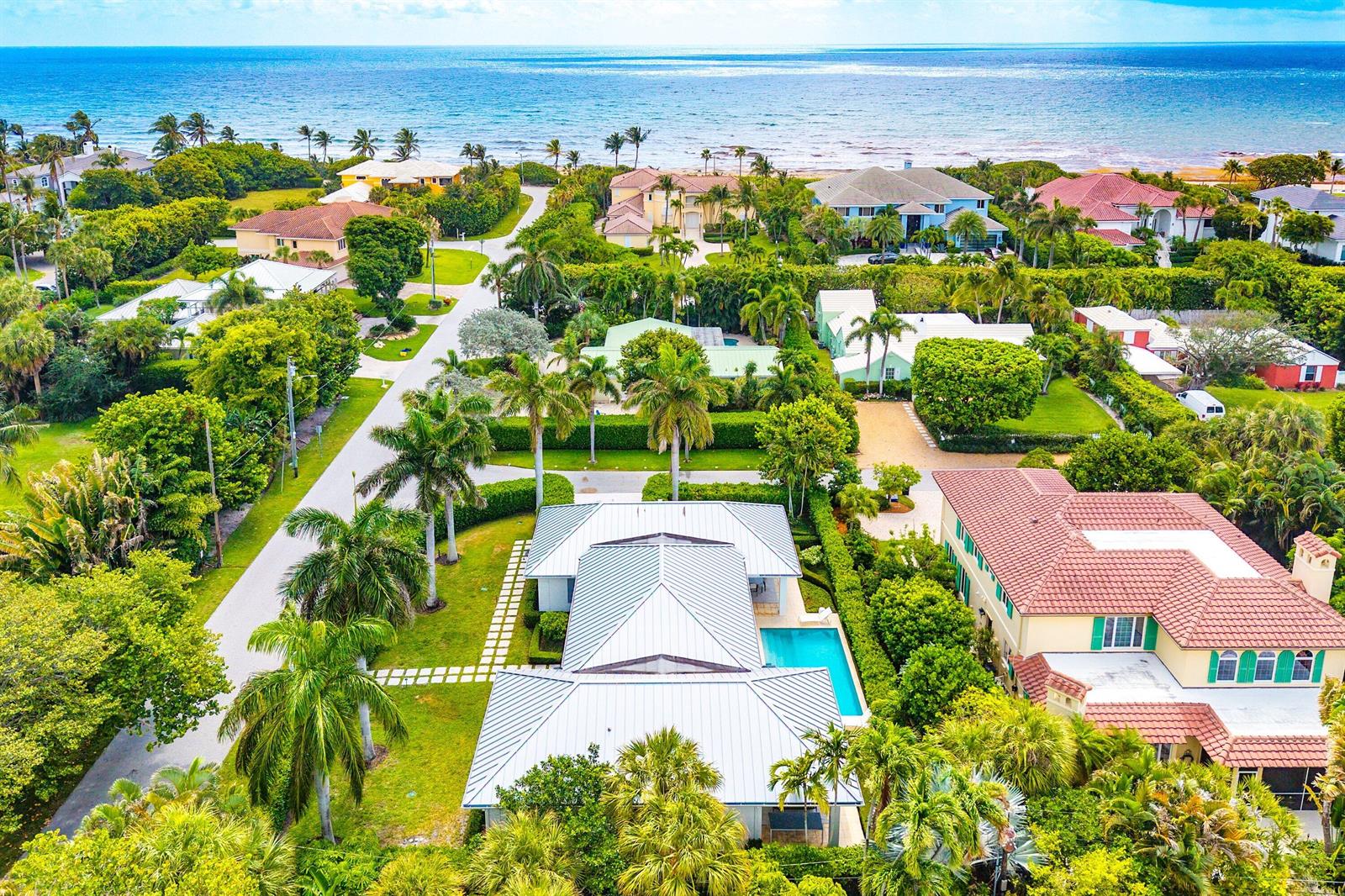 An aerial view shows a coastal neighborhood with houses, lush landscaping, and a swimming pool — 106 Beachway Drive, Ocean Ridge FL 33435, OCEAN RIDGE, FL
