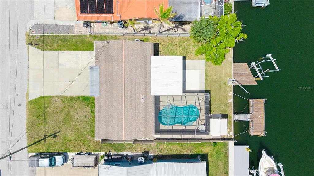 An aerial view shows a house with a pool, screened lanai, and private boat dock — 13912 DARLENE AVENUE, HUDSON, FL