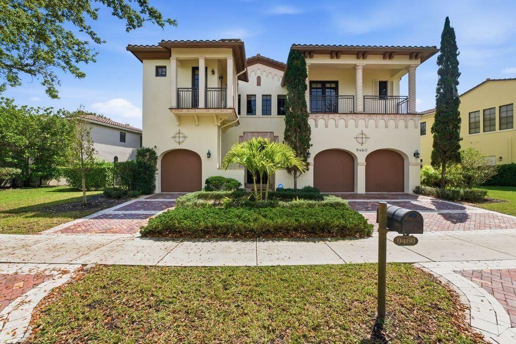 A two-story Mediterranean-style house features a three-car garage, a balcony, and a paved driveway — 9460 Eden Manor, Parkland FL 33076, PARKLAND, FL