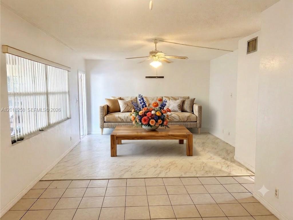 A dining room features a wooden table, tile flooring, and a ceiling fan — 1958 Monroe St # 209, Hollywood FL 33020, HOLLYWOOD, FL