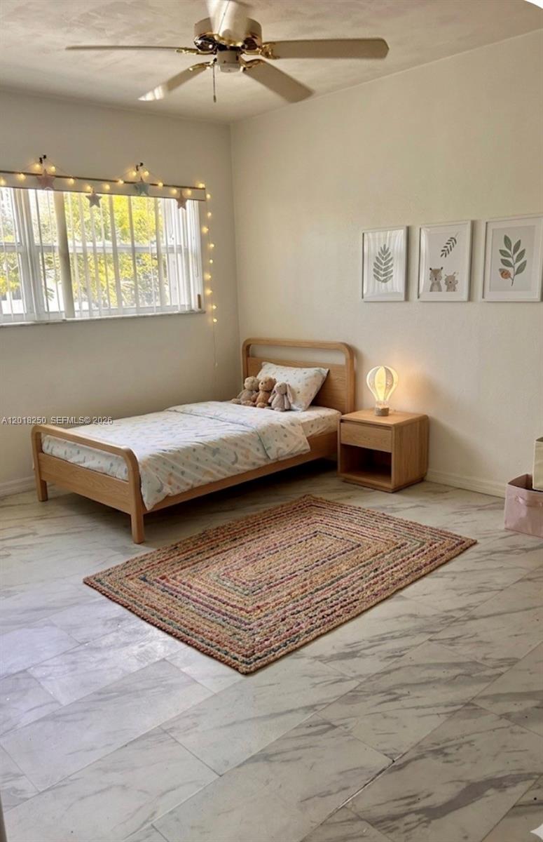 A bedroom features white walls, tile flooring, a ceiling fan, and two open louvered closets — 1958 Monroe St # 209, Hollywood FL 33020, HOLLYWOOD, FL