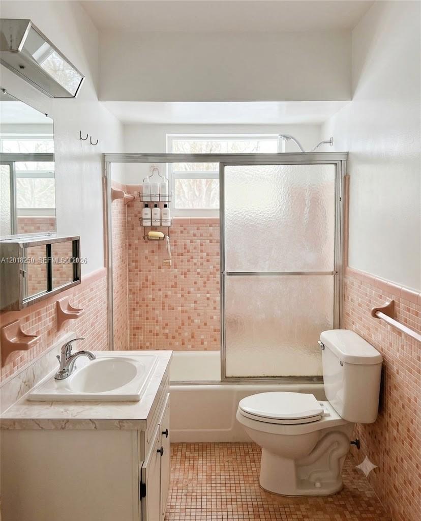 A bedroom features a bed, a wooden dresser, white sliding closets, and marble-look flooring — 1958 Monroe St # 209, Hollywood FL 33020, HOLLYWOOD, FL