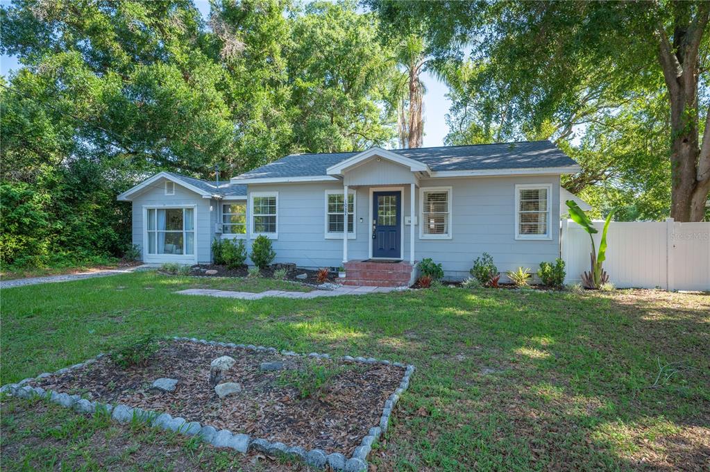 A light gray single-story house with a dark blue front door and a white fence — 1037 JOSEPHINE STREET, LAKELAND, FL