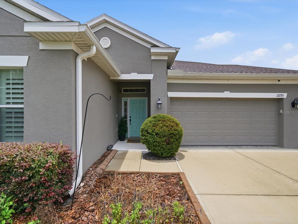 The exterior of a gray house features a light blue front door and a garage — 17735 BRIGHT WHEAT DRIVE, LITHIA, FL