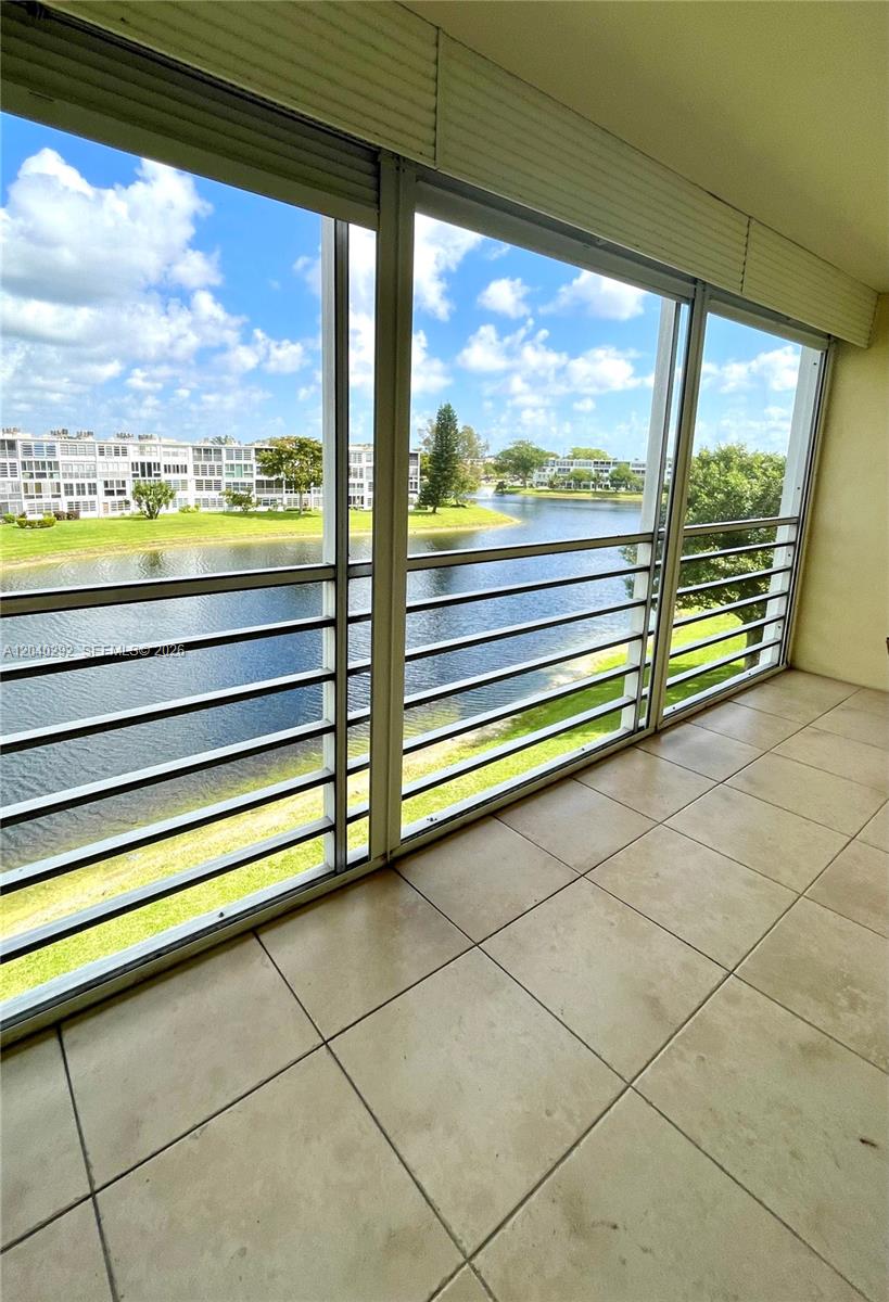 A tiled balcony with metal railings overlooks a lake and residential buildings — 4031 Harwood D # 4031, Deerfield Beach FL 33442, DEERFIELD BEACH, FL
