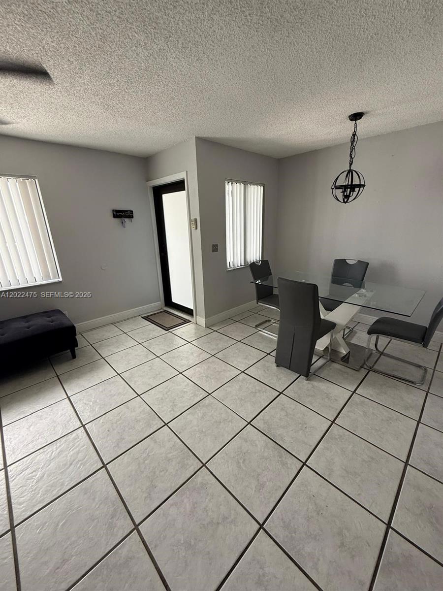 A narrow kitchen with white cabinets, stainless steel appliances, and light-colored tile flooring — 9116 NW 35th Pl # 0, Sunrise FL 33351, SUNRISE, FL