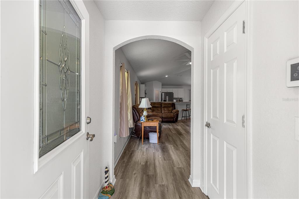 A view from an entryway looking through an arched doorway into a living room — 8774 SE 162ND STREET, SUMMERFIELD, FL